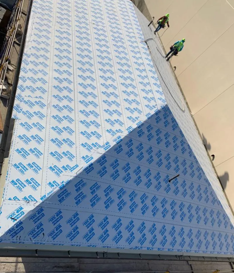 Professional roofers installing underlayment on a metal roof in East Goshen